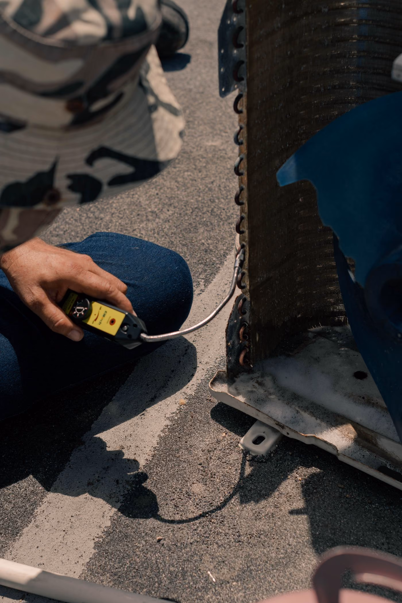 A technician working on outdoor air-conditioning equipment
